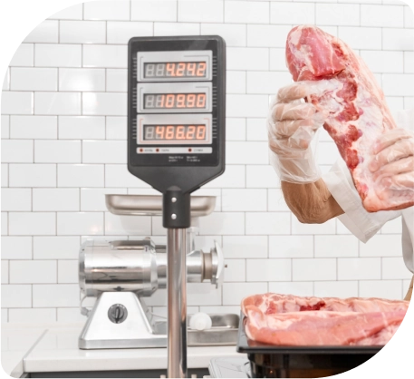 Een man houdt een plak vlees voor een digitale weegschaal, klaar om het te meten