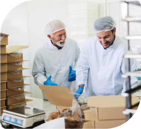 Twee mannen in witte laboratoriumjassen en handschoenen, werkend in een fabriek